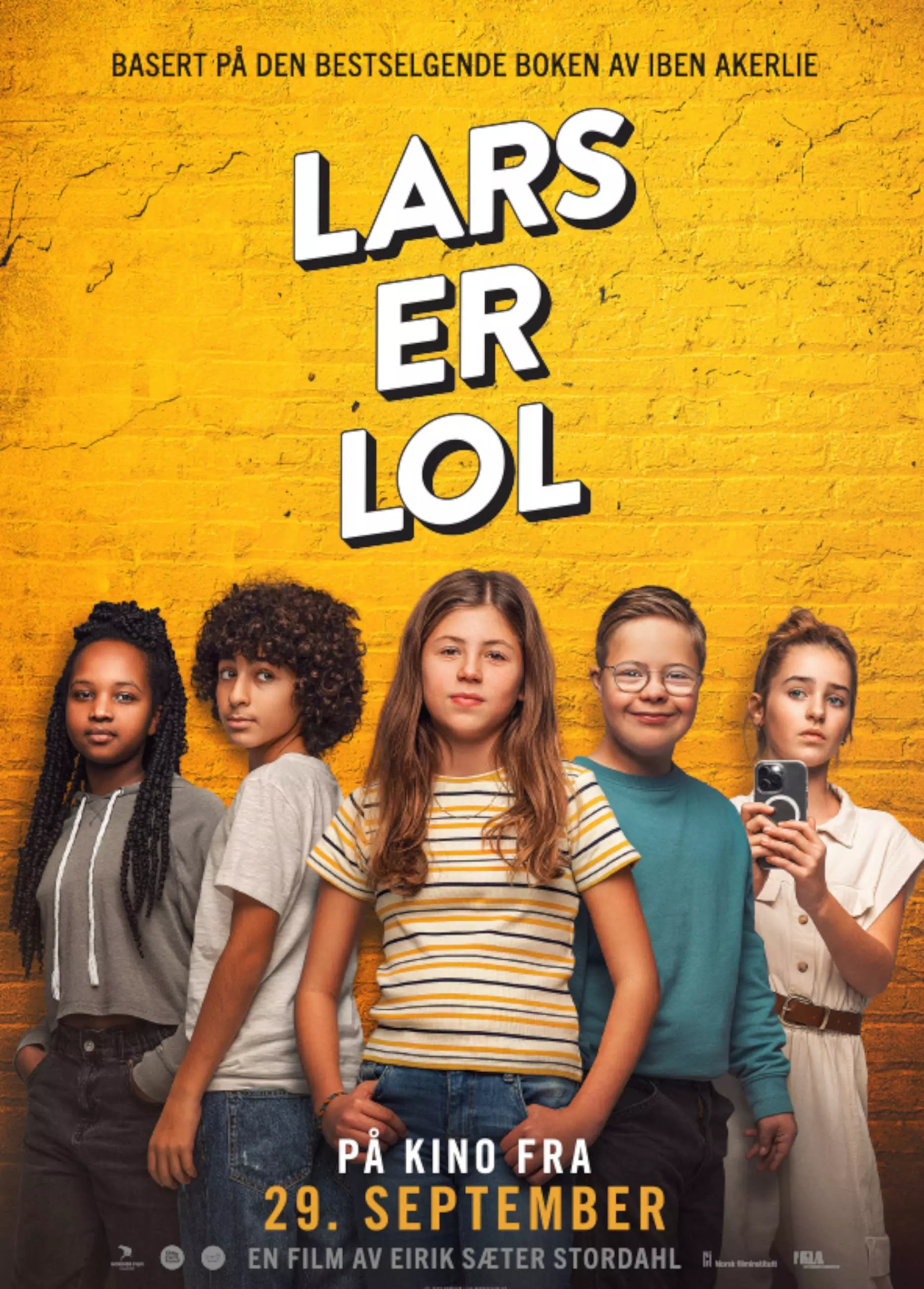 Filmplakat. Fem barn står på rekke. De er omkring 11 år gamle. De står forran en gul murvegg. Over dem står tittelen på filmen med store hvite bokstaver. 