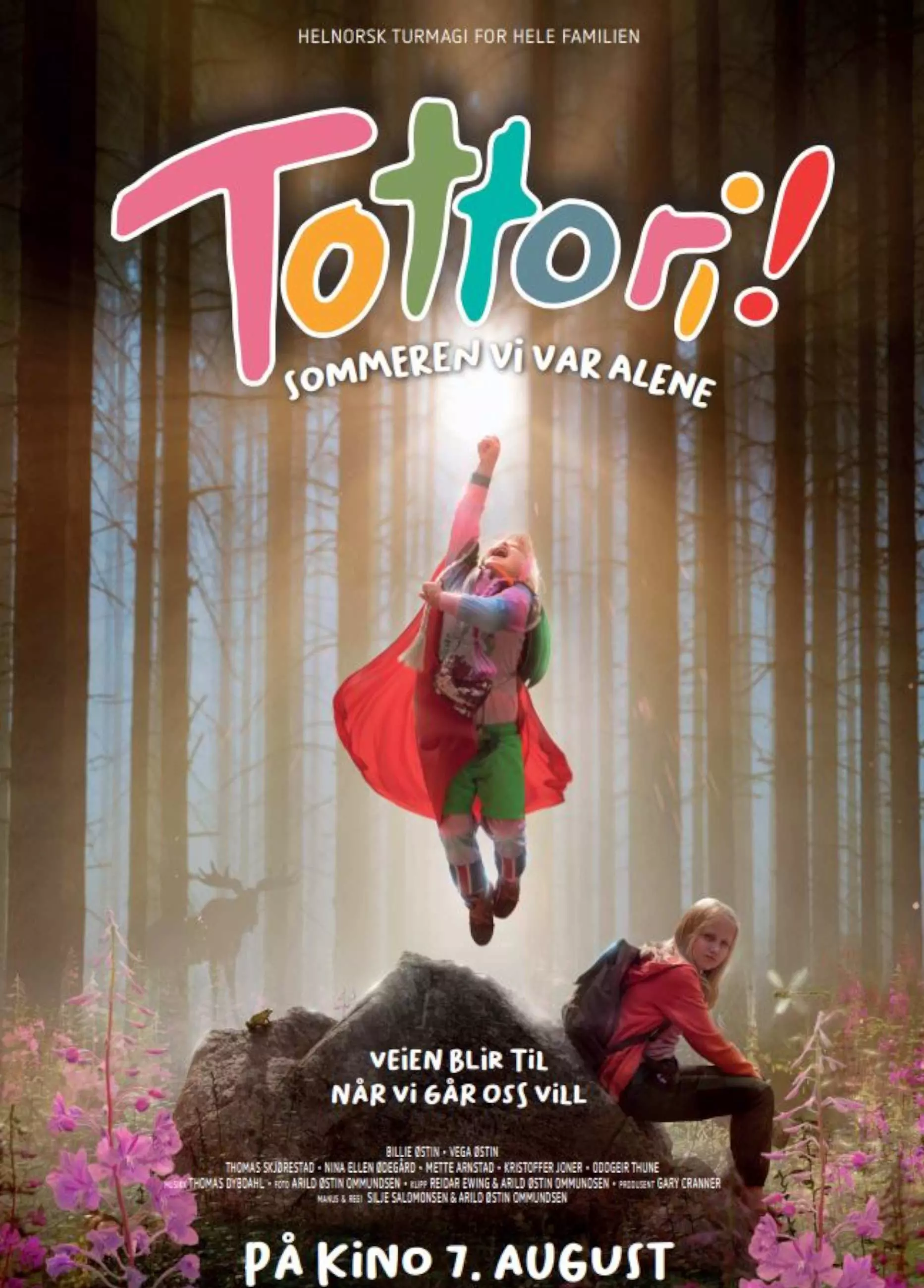 Filmplakat for "Tottori! Sommeren vi var alene". Plakaten har en fargerik og leken skrifttype for tittelen, og viser to barn i en skog. Hun ene svever eller hopper høyt opp fra en stein. Skogen rundt dem har høye trær med lys som strømmer gjennom toppene. Det er også rosa blomster på bakken.