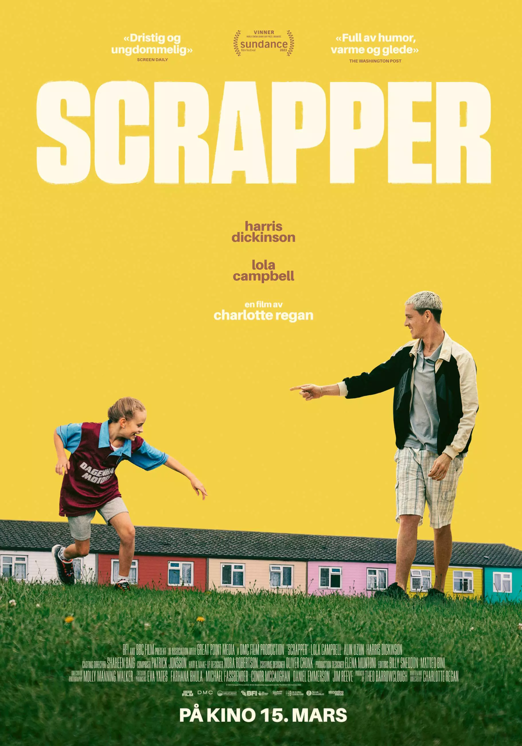 Filmplakat. En ung jente og en ung mann på en plen. Jenta har på seg en fotballdrakt. Begge har på seg shorts. I bakgrunnen er en rekke med fargerike hus. Himmelen er byttet ut med en gul bakgrunn. Øverst på plakaten står filmens tittel i store hvite bokstaver.