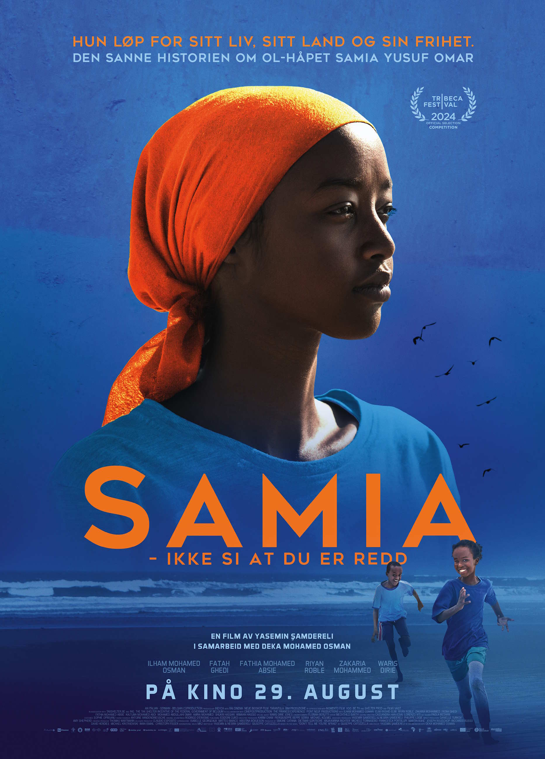 Filmplakat til "Samia - Ikke si at du er redd". En jente med oransje hodeplagg ser bestemt mot høyre på en blå bakgrunn. Foto.