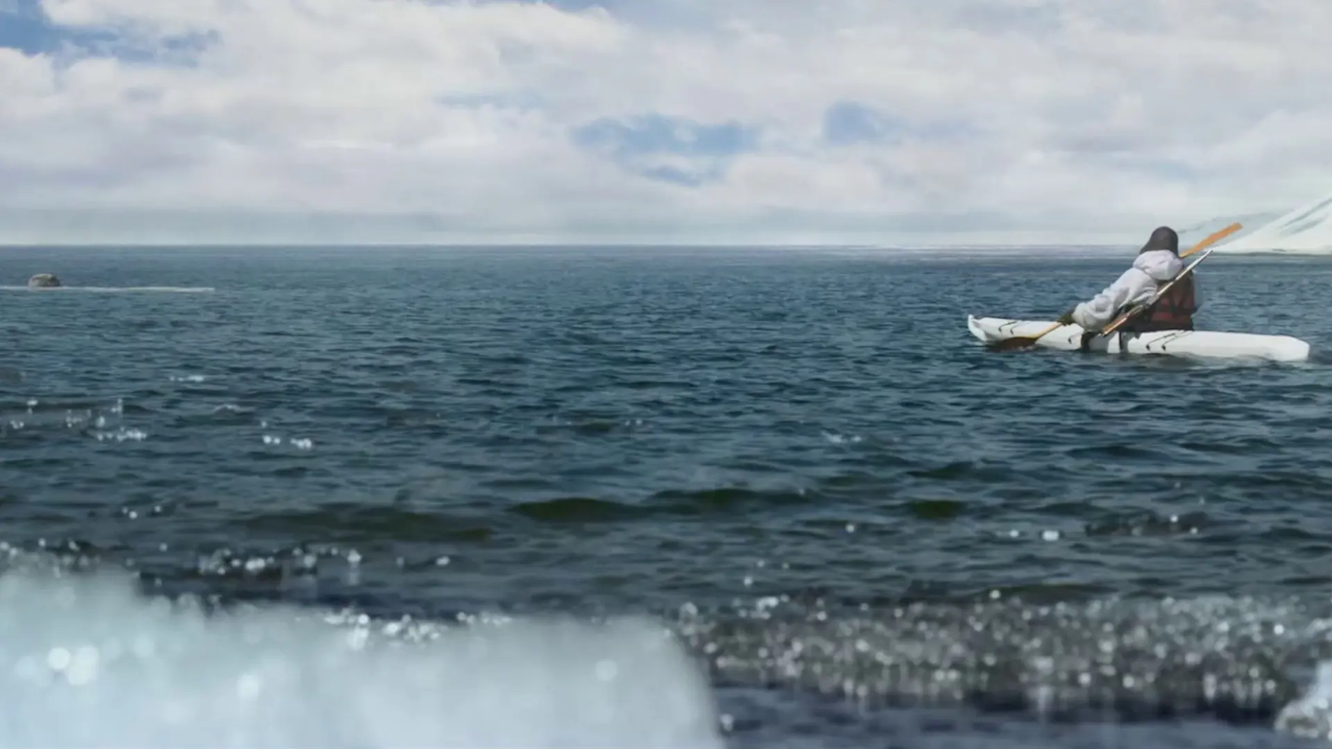 Stillbilde fra "Ask & Ylva - Snørevenes utrolige reise". Person i kayakk på havet. Foto.