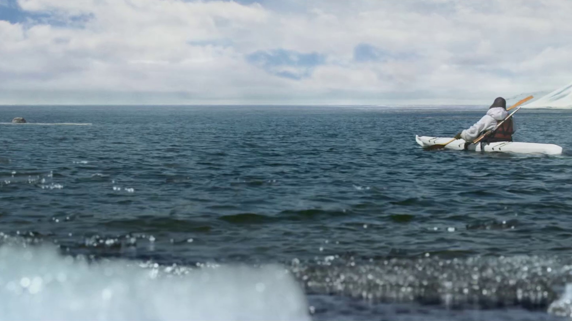 Stillbilde fra "Ask & Ylva - Snørevenes utrolige reise". Person i kayakk på havet. Foto.