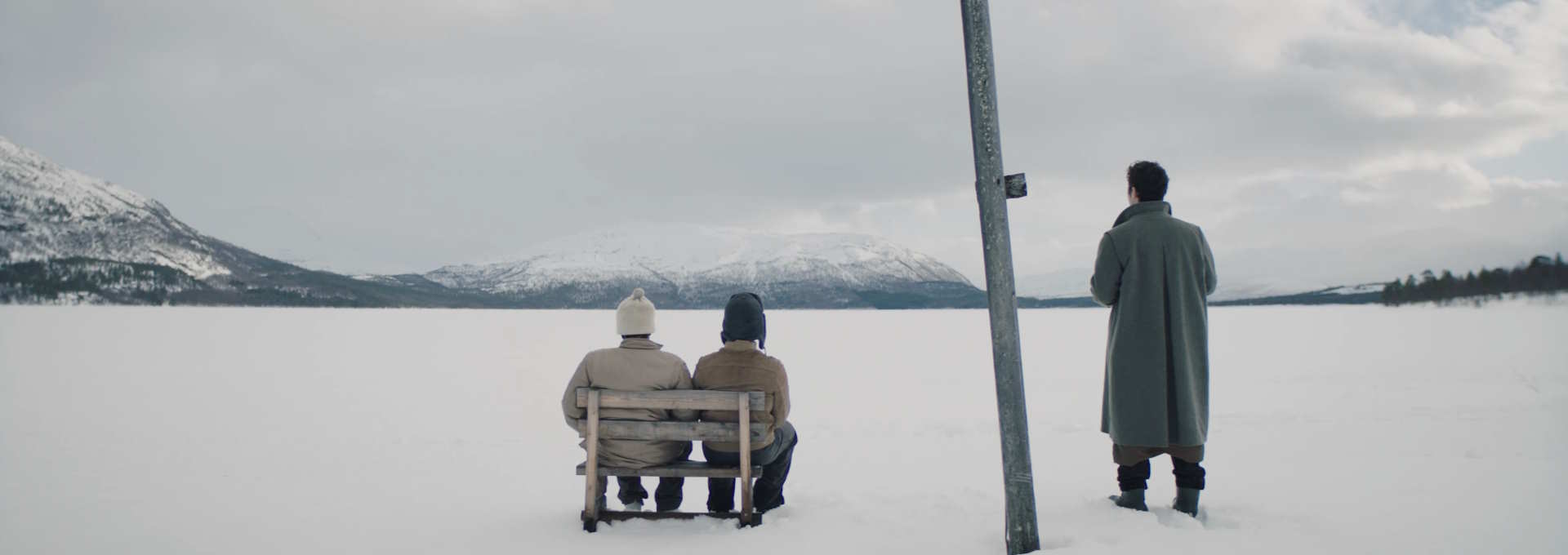 Stillbilde til "A Happy Day". Tre personer skuer utover et snølandskap. Foto.