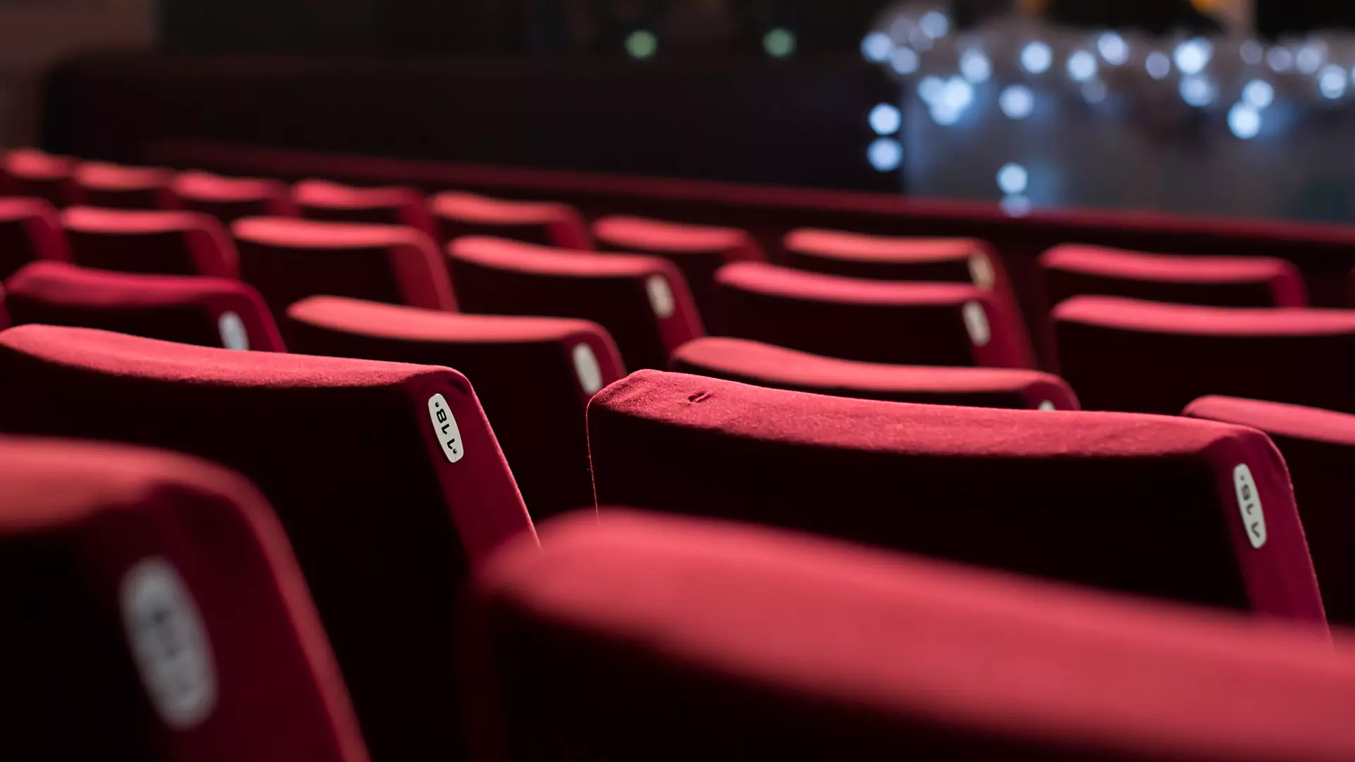 Rader med røde stoler i en kinosal. Foto.