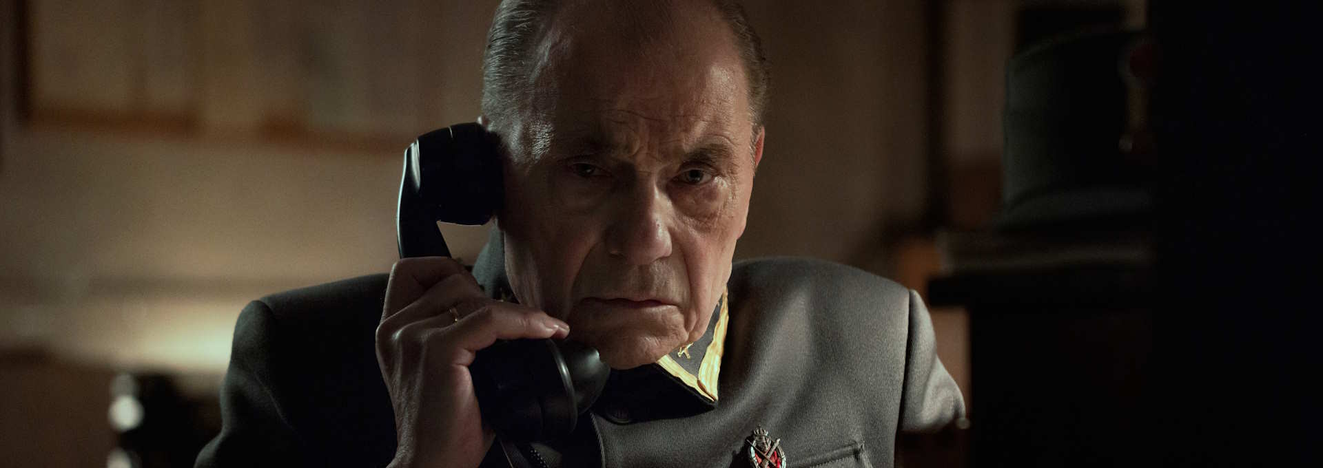 Stillbilde fra "Blücher". Alvorlig mann i telefonen. Foto.
